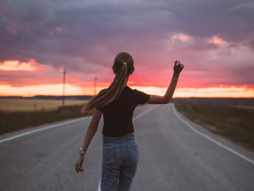 skinny teen walking on sunset road